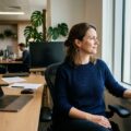 Professionel mand tager pause fra skærmarbejde og kigger væk mod lys vindue for at reducere stress
